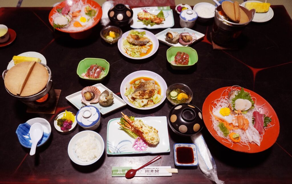 鳥羽の旅館金浦館で食べた夕食 ご飯と伊勢海老のおかずとイカやホタテやマグロの刺身と伊勢海老の入った鍋