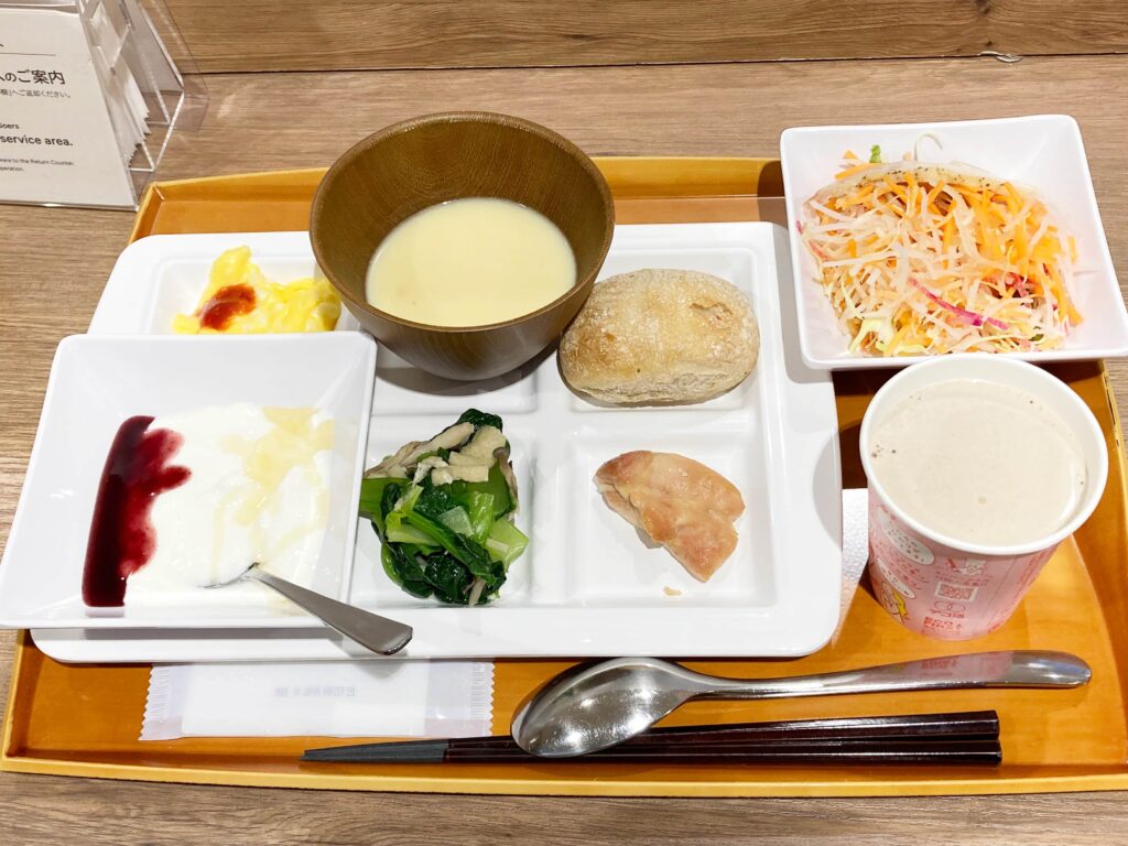 福岡のスーパーホテルの朝食　パンとコーンスープと野菜炒めと照り焼きチキンとスクランブルエッグと生野菜サラダとヨーグルトとカフェオレ