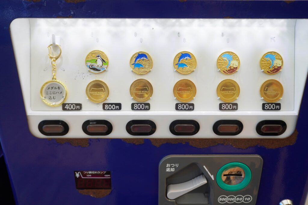 福岡んおマリンワールド海の中道で購入できる来館記念メダルの販売機を撮影した写真