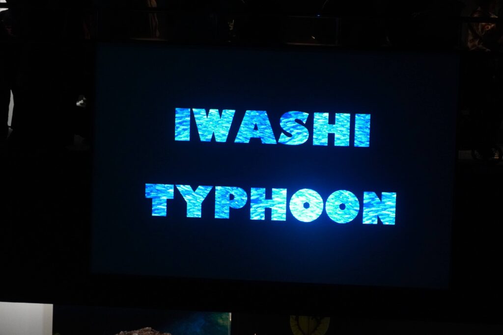 福岡のマリンワールド海の中道で開催されるイワシタイフーン 開始時に英語でIWASHI TYPHOONの文字が映し出された外洋大水槽横のモニター